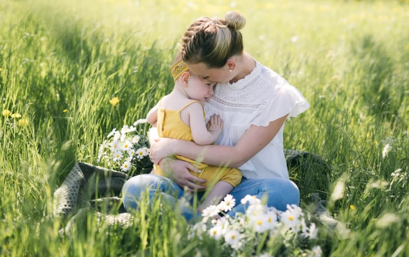 Mutter hält ihr Kind auf einer Blumenwiese – Originalbild von MuKiLein